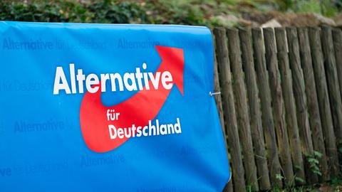 Ein Banner mit dem Logo der Partei Alternative für Deutschland (AfD) hängt an einem Zaun.