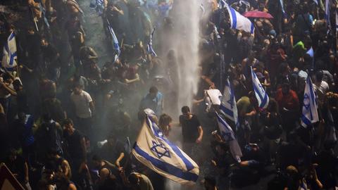 Bereitschaftspolizei versucht, Demonstranten während einer Demonstration in Tel Aviv gegen die Justizreform mit einem Wasserwerfer zu vertreiben. 