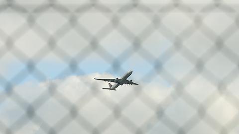 Startendes Flugzeug durch einen Zaun fotografiert