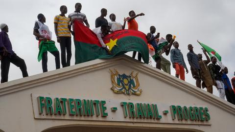 In Niamey (Niger) demonstrieren Bürger am und auf dem Eingang zur Nationalversammlung.