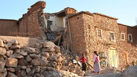 Kinder stehen bei einem beschädigten Gebäude in der Nähe von Marrakesch nach einem Erdbeben