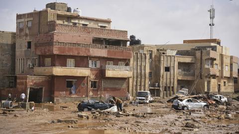 Auf diesem von der libyschen Regierung zur Verfügung gestellten Bild liegen Autos und Trümmer in einer Straße in Derna, Libyen