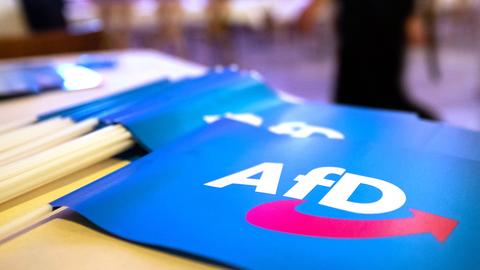 Papierfahnen mit dem AFD-Logo liegen auf einem Tisch