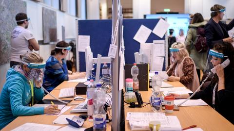 Mitarbeiter mit Schutzmasken telefonieren im Gesundheitsamt Berlin Mitte  (dpa)