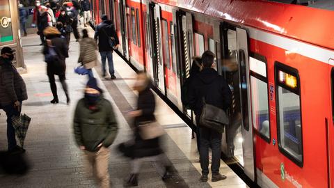 In Hamburg steigen Menschen mit Schutzmasken aus und in eine S-Bahn. (dpa)