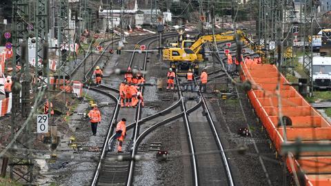 Arbeiter und ein Krahn starten mit den Sanierungsarbeiten an der Riedbahn