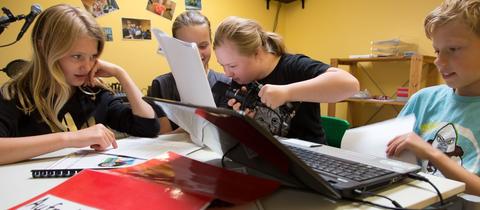 Schüler*innen nehmen in einem Tonstudio in der Grundschule ein Hörspiel auf.