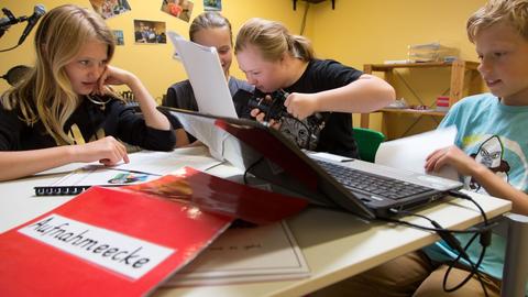 Schüler*innen nehmen in einem Tonstudio in der Grundschule ein Hörspiel auf.