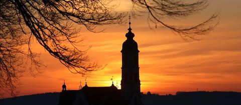 Hinter der Wallfahrtskirche "Unserer Lieben Frau" geht am Morgen die Sonne auf. 