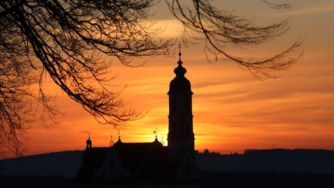 Hinter der Wallfahrtskirche "Unserer Lieben Frau" geht am Morgen die Sonne auf. 