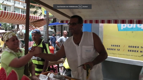 Mann und Frau geben sich die Hand auf einem Markt