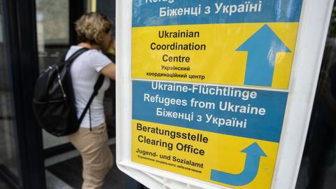 Besucher gehen an einem Hinweisschild der Initiative Ukrainian Coordination Center (UCC) am Eingang zum Amt für multikulturelle Angelegenheiten der Stadt Frankfurt am Main vorbei.