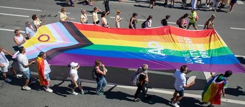 Teilnehmer der Antwerp Pride-Parade 2022 ziehen mit einer großen Intersex Inclusive Pride Flag durch die Straßen.