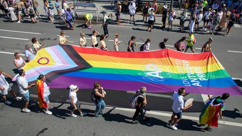 Teilnehmer der Antwerp Pride-Parade 2022 ziehen mit einer großen Intersex Inclusive Pride Flag durch die Straßen.