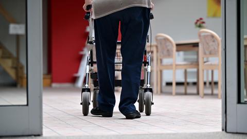 Ein Bewohner des Pflegezentrum geht mit dem Rollator durchs Haus.