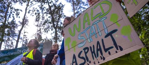 Umweltschützer protestieren mit einer Aktion am Waldrand gegen die geplante Rodung des Stadtwalds.