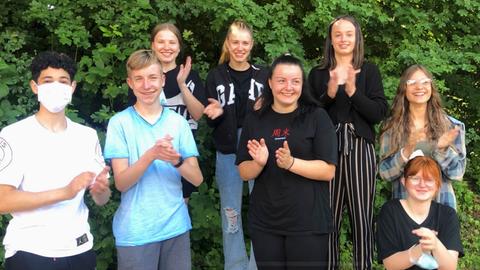 Schüler und Schülerinnen der Leo-Sternberg-Schule in Limburg stehen im Freien und freuen sich