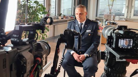Der Leiter der Polizeidirektion Main-Kinzig, Jürgen Fehler sitzt vor Kameras im hr-Interview.