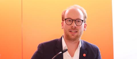 Max Viessmann vor orange Hintergrund