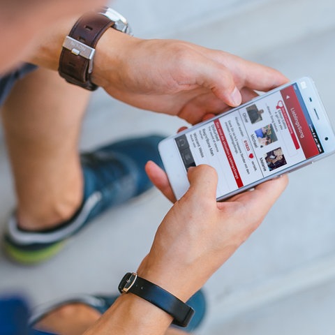 Junger Mann schaut auf die hr3 Radio-App des Hessischen Rundfunks