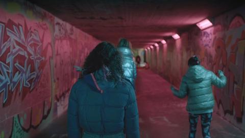 Dunkle, triste, verschmierte  Fussgängerunterführung 3 Damen laufen in den Tunnel