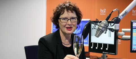 Angelika Bierbaum mit Sektglas im hr2-Studio.