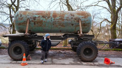 Tankwagen (Anhänger) eines Landwirts steht auf einer Straße, davor steht Motivaufnahmeleiter und Green Consultant Robert Hertel