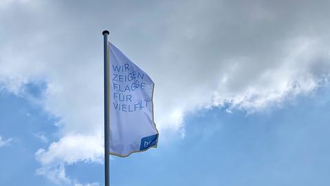 Fahne mit der Aufschrift "Wir zeigen Flagge für Vielfalt" vor dem Haupteingang des hr. 
