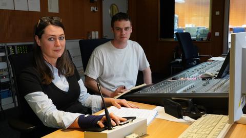 Silke Hildebrandt (Regisseurin) und  Aran Kleebaur (Regieassistent) sitzen im Technikraum des Hörspielstudios