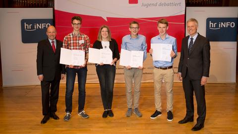 Die vier Gewinner von "Jugend debattiert 2018" zusammen mit Ansgar Kemmann (Leiter "Jugend debattiert") und Dr. Manuel Lösl (Staatssekretär im Hessischen Kultusministerium)