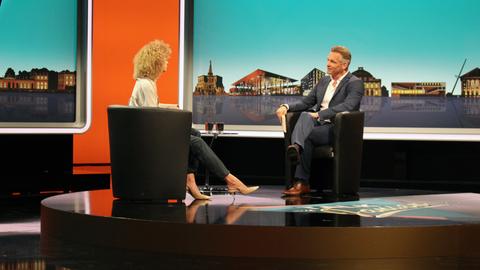 Im Fernsehstudio führt der fiktive Moderator ein Interview mit einem fiktiven weiblichen Talkgast.