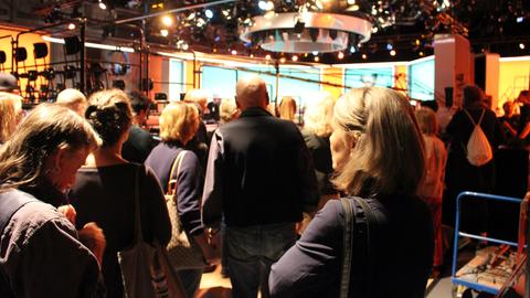 Zahlreiche Komparsen treffen im Fernsehstudio ein.