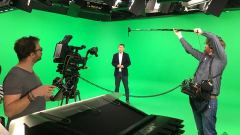 Sebastian Kisters vor grünem Hintergrund im Studio bei den #kurzerklärt-Aufnahmen