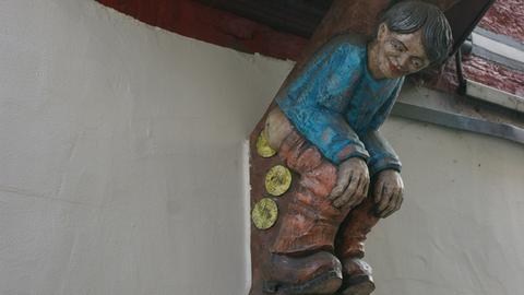 Hölzerne Figur am Fachwerkhaus in Herborn: Muenzschisser