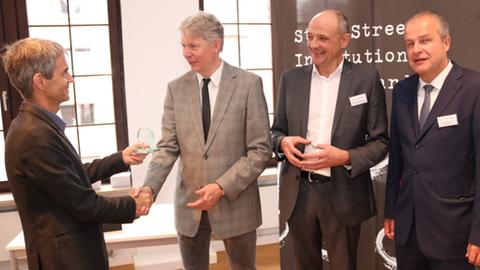 Laudator Reto Schlatter (Schweizer Journalistenschule) gratuliert Stefan Jäger, Ingo Nathusius und Andreas Niklaus (State Street Corporation).