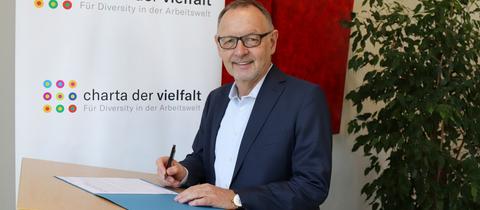 hr-Intendant Manfred Krupp unterzeichnet beim Unterzeichnen der Urkunde t die "Charta der Vielfalt"