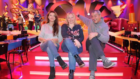 Gisela Kröhn, Marika Braun und Axel Mugler sitzen auf einer Treppe. Im Hintergrund das neue Bühnenbild.