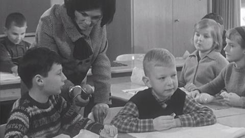 1963: Reporterin mit Schülern im Klassenzimmern