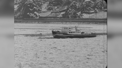 Einstellung aus einem "hessenschau"-Beitrag von 1963. In Schwarz-Weiß ist der zugefrorene Rhein mit einem kleinen Schiff darauf zu sehen.