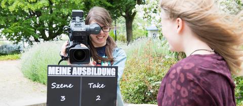 Zwei Schülerinnen mit einer Filmklappe