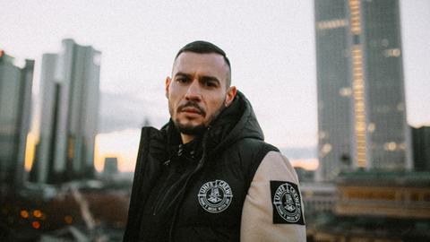 Der Rapper Bosca vor der Skyline in Frankfurt am Main