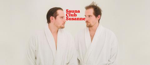 Key Visual von Saunaclub Susanne: Die beiden Hosts stehen sich im Bademantel gegenüber