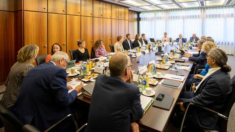 Mitglieder des Verwaltungsrats sitzen in einem Konferenzraum rund um einen großen Konferenztisch